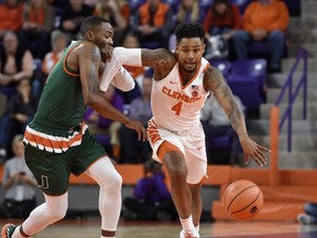 Clemson's Shelton Mitchell drives the ball up the court while defended by Miami's Ja'Quan Newton during the first half of an NCAA college basketball game Saturday, Jan. 13, 2018, in Clemson, S.C.