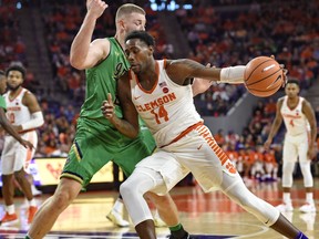 Clemson's Elijah Thomas (14) drives against Notre Dame's Martinas Geben during the first half of an NCAA college basketball game Saturday, Jan. 20, 2018, in Clemson, S.C.