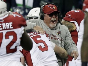 Arizona Cardinals head coach Bruce Arians is hugged by quarterback Drew Stanton (5) after Seattle Seahawks kicker Blair Walsh missed a field goal at the end of an NFL football game, Sunday, Dec. 31, 2017, in Seattle.