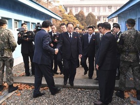 In this photo provided by South Korea Unification Ministry, the head of North Korean delegation Jon Jong Su, center, is greeted by a South Korean official as he crosses a border line to attend their meeting at Panmunjom in the Demilitarized Zone in Paju, South Korea, Wednesday, Jan. 17, 2018. The two Koreas are meeting Wednesday for the third time in about 10 days to continue their discussions on Olympics cooperation, days ahead of talks with the IOC on North Korean participation in the upcoming Winter Games in the South. (South Korea Unification Ministry via AP)