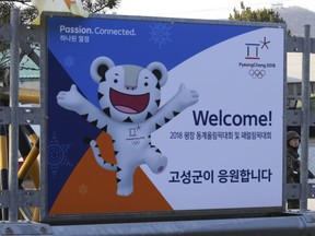 A South Korean army soldier stands guard behind a poster showing the 2018 Pyeongchang Winter Olympic mascot at the Unification Observation post in Goseong, near the border with North Korea, South Korea, Friday, Jan. 19, 2018. The rival Koreas agreed Wednesday to form their first unified Olympic team and have their athletes parade together for the first time in 11 years during the opening ceremony of next month's Winter Olympics in South Korea, officials said.