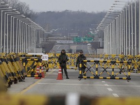 South Korean army soldiers stand guard on Unification Bridge, which leads to the demilitarized zone, near the border village of Panmunjom in Paju, South Korea, Thursday, Jan 4, 2018. North Korean leader Kim Jong Un reopened a key cross-border communication channel with South Korea for the first time in nearly two years Wednesday as the rivals explored the possibility of sitting down and talking after months of acrimony and fears of war.