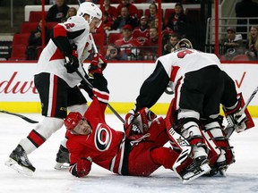 Carolina Hurricanes' Lee Stempniak goes to the ice after colliding with Ottawa Senators goaltender Craig Anderson with Senators Dion Phaneuf nearby during the second period Tuesday in Raleigh, N.C. The Hurricanes won 2-1.