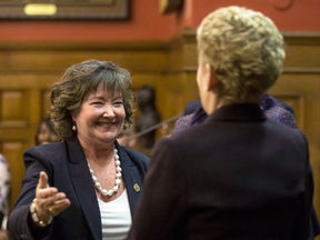 Kathryn McGarry, Ontario's new Minister for Transportation, left, greets Premier Kathleen Wynne during a swearing-in ceremony following a cabinet shuffle on Wednesday.