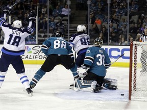 Winnipeg Jets' Mathieu Perreault (85) deflects a shot for a goal past San Jose Sharks goaltender Aaron Dell (30) during the first period of an NHL hockey game Tuesday, Jan. 23, 2018, in San Jose, Calif.