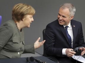 German Chancellor Angela Merkel, left, and the President of the Parliament of France, Francois de Rugy, right, attend a joint meeting of the German and the French parliament at the Bundestag, in the Reichstag building in Berlin, Germany, Monday, Jan. 22, 2018.