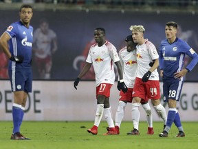 Leipzig's Kevin Kampl, 2nd right, hugs his teammate and scorer Naby Keita, center, as they celebrate the opening goal during the German Bundesliga soccer match between RB Leipzig and FC Schalke 04 in Leipzig, Germany, Saturday, Jan. 13, 2018.