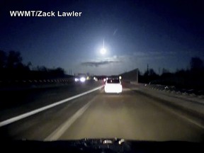 In this late Tuesday, Jan. 16, 2018, image made from dashcam video, a brightly lit object falls from the sky above a highway in the southern Michigan skyline.