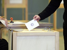 A voter casts his ballot during the presidential elections at the Helsinki City Hall in Helsinki, Finland Sunday, Jan. 28, 2018. Finns are voting for a new president in an election that's expected to see the highly popular incumbent score a win during Sunday's first round.