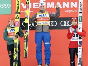 Maren Lundby of Norway, center, celebrates her win on the podium, along with second placed Germany's Katharina Althaus and third placed Japan's Sara Takanashi, during a World Cup ski jumping event in Sapporo, northern Japan, Saturday, Jan. 13, 2018.
