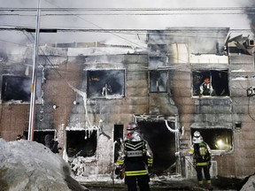 Firefighters work at the scene of a fire in Sapporo, northern Japan, early Thursday, Feb. 1, 2018.  Japanese media say 11 people have died in a fire that engulfed a home for elderly welfare recipients in northern Japan. The fire broke out before midnight Thursday in Sapporo, the main city on the island of Hokkaido.