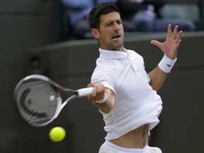 FILE - In this July 12, 2017, file photo, Serbia's Novak Djokovic returns to Czech Republic's Tomas Berdych during their Men's Singles Quarterfinal Match on day nine at the Wimbledon Tennis Championships in London. Djokovic is back after the longest injury layoff of his career and he's clearly enjoying himself on the court again. Wearing a compression sleeve on his right arm to protect his troublesome elbow, Djokovic dominated the fifth-ranked Dominic Thiem 6-1, 6-4 on Wednesday, Jan. 10, 2018, in an exhibition match at the Kooyong Classic, a key tune-up event for next week's Australian Open.