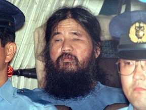 FILE - In this Sept. 25, 1995, file photo, cult leader Shoko Asahara, center, sits in a police van following an interrogation in Tokyo. More than two decades after poison gas attacks in Tokyo's subways killed 13 people, the stage has shifted to the execution of the 13 major perpetrators. Just when they will be sent to the gallows though remains a mystery in Japan's highly secretive death-penalty system. Asahara, the guru of Aum Shinrikyo, and 12 others have been sentenced to death. Whether any will be hanged in 2018 is impossible to know. Japan generally announces an execution only after it has happened. (Kyodo News via AP, File)