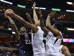 Los Angeles Clippers guard Lou Williams (23) shoots against Memphis Grizzlies forward Ivan Rabb, center, and guard Mario Chalmers, right, during the first half of an NBA basketball game Friday, Jan. 26, 2018, in Memphis, Tenn.