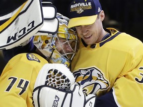 Nashville Predators goalie Juuse Saros (74), of Finland, gets a hug from fellow goalie Pekka Rinne (35), of Finland, after Saros stopped 43 shots to shut out the Vegas Golden Knights 1-0 in an NHL hockey game Tuesday, Jan. 16, 2018, in Nashville, Tenn.
