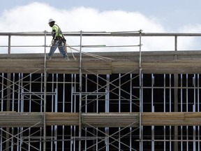 In this Friday, Oct. 6, 2017, photo, workers build an apartment and retail complex in Nashville, Tenn. On Wednesday, Jan. 3, 2018, the Commerce Department reports on U.S. construction spending in November.