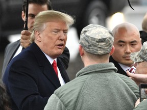 President Donald Trump is greeted by military personnel as he arrives at Nashville International Airport in Nashville, Tenn., Monday, Jan. 8, 2018, to speak at the American Farm Bureau Federation's Annual Convention.