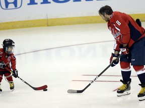 Washington Capitals forward Alexander Ovechkin (8) passes the puck to a young fan before the Skills Competition, part of the NHL All-Star Game events, Saturday, Jan. 27, 2018, in Tampa, Fla.