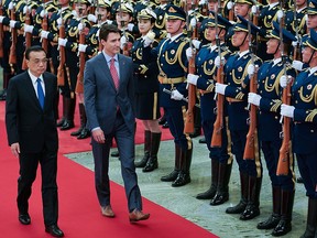 Prime Minister Justin Trudeau is accompanied by Chinese Premier Li Keqiang as he views an honour guard inside the Great Hall of the People on Dec. 4, 2017, in Beijing.