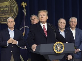 U.S. President Donald Trump answers reporters’ questions on Jan. 6, 2018, at Camp David, flanked by Vice-President Mike Pence, Cabinet members and Republican congressional leaders.
