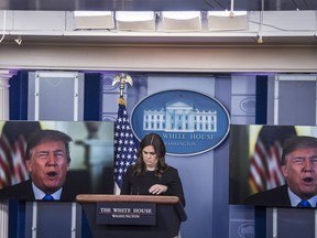 A video of President Trump making remarks is played on dual screens in the White House briefing room as press secretary Sarah Huckabee Sanders waits to talk to reporters on Thursday.