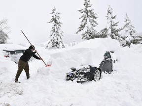 A man removes snow from his car at the Sestriere skiing resort, in the Italian Alps, Tuesday, Jan. 9, 2018. Italy is warning of extreme avalanche danger in its northwest Alpine regions, while an avalanche has hit an apartment building in Sestriere causing no injuries but its evacuation, and high snow and other avalanches blocked roads and isolated villages in the Piedmont and Valle d'Aosta regions.