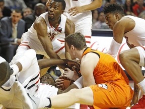 Oklahoma State's Mitchell Solomon (41) tries to keep the ball away from Texas Tech's Norense Odiase (32) and Keenan Evans (12) during the first half of an NCAA college basketball game Tuesday, Jan. 23, 2018, in Lubbock, Texas.