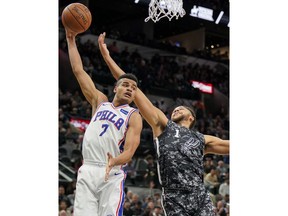 Philadelphia 76ers' Timothe Luwawu-Cabarrot (7) grabs a rebound next to San Antonio Spurs' Kyle Anderson during the first half of an NBA basketball game Friday, Jan. 26, 2018, in San Antonio.