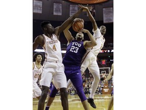 TCU forward Ahmed Hamdy-Mohamed (23) battles Texas forward Mohamed Bamba (4) and guard Matt Coleman (2) for a rebound during the first half of an NCAA college basketball game Wednesday, Jan. 10, 2018, in Austin, Texas.