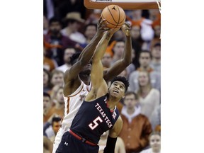 Texas forward Mohamed Bamba (4) grabs a rebound over Texas Tech guard Justin Gray (5) during the first half of an NCAA college basketball game, Wednesday, Jan. 17, 2018, in Austin, Texas.