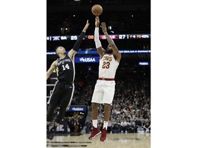 Cleveland Cavaliers forward LeBron James (23) shoots and scores over San Antonio Spurs guard Danny Green (14) during the first half of an NBA basketball game, Tuesday, Jan. 23, 2018, in San Antonio. The score allowed James to reach the 30,000 milestone for his career.