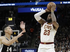 Cleveland Cavaliers forward LeBron James (23) shoots and scores over San Antonio Spurs guard Danny Green (14) during the first half of an NBA basketball game, Tuesday, Jan. 23, 2018, in San Antonio. The score allowed James to reach the 30,000 milestone for his career.