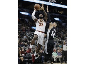 Cleveland Cavaliers forward LeBron James (23) scores over San Antonio Spurs guard Danny Green (14) during the first half of an NBA basketball game, Tuesday, Jan. 23, 2018, in San Antonio.