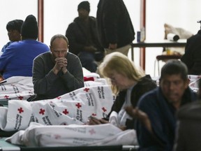 Jeremy Roberts sits on a cot at a warming shelter opened by the Harris County Precinct One Constables Office and the American Red Cross at Pleasant Grove Missionary Baptist Church as freezing weather moves through the region Tuesday, Jan. 16, 2018, in Houston.