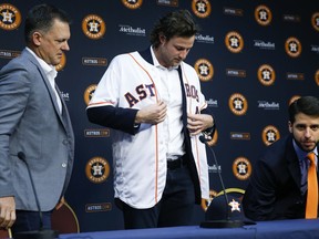 Houston Astros manager AJ Hinch, left, and Senior Director of Baseball Operations Brandon Taubman, right, introduce pitcher Gerrit Cole, who was acquired in a trade with the Pittsburgh Pirates, Wednesday, Jan. 17, 2018 in Houston.