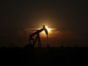 FILE - This June 27, 2017, file photo shows an oil rig at sunset in Midland, Texas. President Donald Trump relentlessly congratulates himself for the healthy state of the U.S. economy, with its steady growth, low unemployment, busier factories and confident consumers. But in the year since Trump's inauguration, most economists tend to agree on this: The economy has essentially been the same sturdy one that he inherited from Barack Obama.