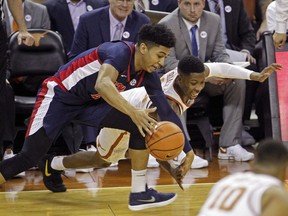 Mississippi guard Breein Tyree, left, fights for a loose ball with Texas guard Kerwin Roach, right, during the first half of an NCAA college basketball game, Saturday, Jan. 27, 2018, in Austin, Texas.