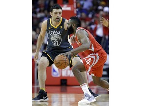 Houston Rockets guard James Harden (13) drives around Golden State Warriors center Zaza Pachulia (27) during the first half of an NBA basketball game Saturday, Jan. 20, 2018, in Houston.