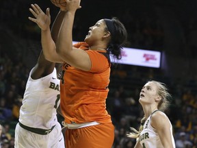 Oklahoma State center Kaylee Jensen, right, shoots past Baylor forward Dekeiya Cohen, left and guard Kristy Wallace, right, during the first half of an NCAA college basketball game, Wednesday, Jan. 31, 2018, in Waco, Texas.
