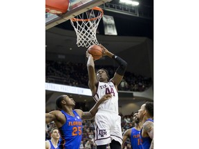 Texas A&M forward Robert Williams (44) makes a basket over Florida forward Keith Stone (25) during the first half of an NCAA college basketball game Tuesday, Jan. 2, 2018, in College Station, Texas.