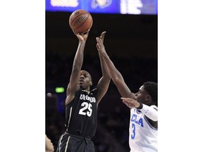 Colorado guard McKinley Wright IV, left, shoots as UCLA guard Aaron Holiday defends during the first half of an NCAA college basketball game Saturday, Jan. 13, 2018, in Los Angeles.