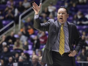 FILE - In this Jan. 4, 2018, file photo, Northern Arizona coach Jack Murphy calls to his team during the first half of an NCAA college basketball game against Weber State, in Ogden, Utah. High-major college basketball programs fly on chartered jets, stay in upscale hotels and eat at nice restaurants. The smallest of the 351 schools in Division I fly coach, look for hotel and meal deals and are forced to catch early-morning flights the day after games to get back to school. The difference in travel arrangements takes a toll.