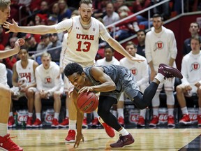 Arizona State guard Tra Holder (0) drives around Utah forward David Collette (13) in the first half during an NCAA college basketball game Sunday, Jan. 7, 2018, in Salt Lake City.