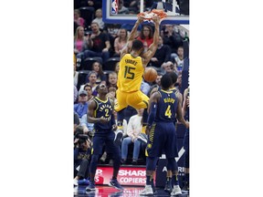 Utah Jazz forward Derrick Favors (15) dunks as Indiana Pacers' Darren Collison (2) and Victor Oladipo (4) look on in the first half during an NBA basketball game Monday, Jan. 15, 2018, in Salt Lake City.