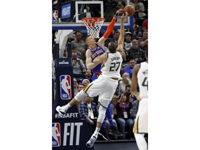 New York Knicks forward Kristaps Porzingis, rear, defends against Utah Jazz center Rudy Gobert (27) during the first half of NBA basketball Friday, Jan. 19, 2018, in Salt Lake City.