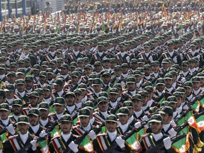 FILE - In this Sept. 21, 2012 photo, Iran's Revolutionary Guard troops march during a military parade commemorating the anniversary of start of the 1980-88 Iraq-Iran war, in front of the shrine of the late revolutionary founder Ayatollah Khomeini, just outside Tehran, Iran. Supreme Leader Ayatollah Ali Khamenei has ordered the Revolutionary Guard to loosen its hold on the economy, the country's defense minister says, raising the possibility that the paramilitary organization might privatize some of its vast holdings.