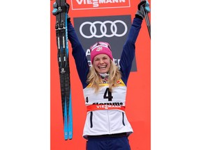 Third placed Jessica Diggins of the United States celebrates on the podium of a cross-country ski women's 9 km Final Climb Pursuit race, at the FIS Tour de Ski event in Val di Fiemme, Italy, Sunday, Jan. 7, 2018.