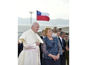 In this picture made available Tuesday, Jan. 16, 2018, Pope Francis is welcomed by Chile's President Michelle Bachelet, right, upon his arrival at the international airport in Santiago, Chile, Monday, Jan. 15, 2018. (L'Osservatore Romano/Pool Photo via AP)