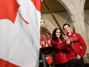 Tessa Virtue and Scott Moir get their chance to hold the flag at the announcement they will be the flag bearers for the opening ceremony at the 2018 Winter Olympics.
