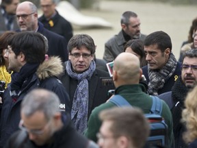 Ousted Catalan leader Carles Puigdemont, center, walks in the park with elected Catalan lawmakers of his Together for Catalonia party in Brussels on Friday, Jan. 12, 2018.